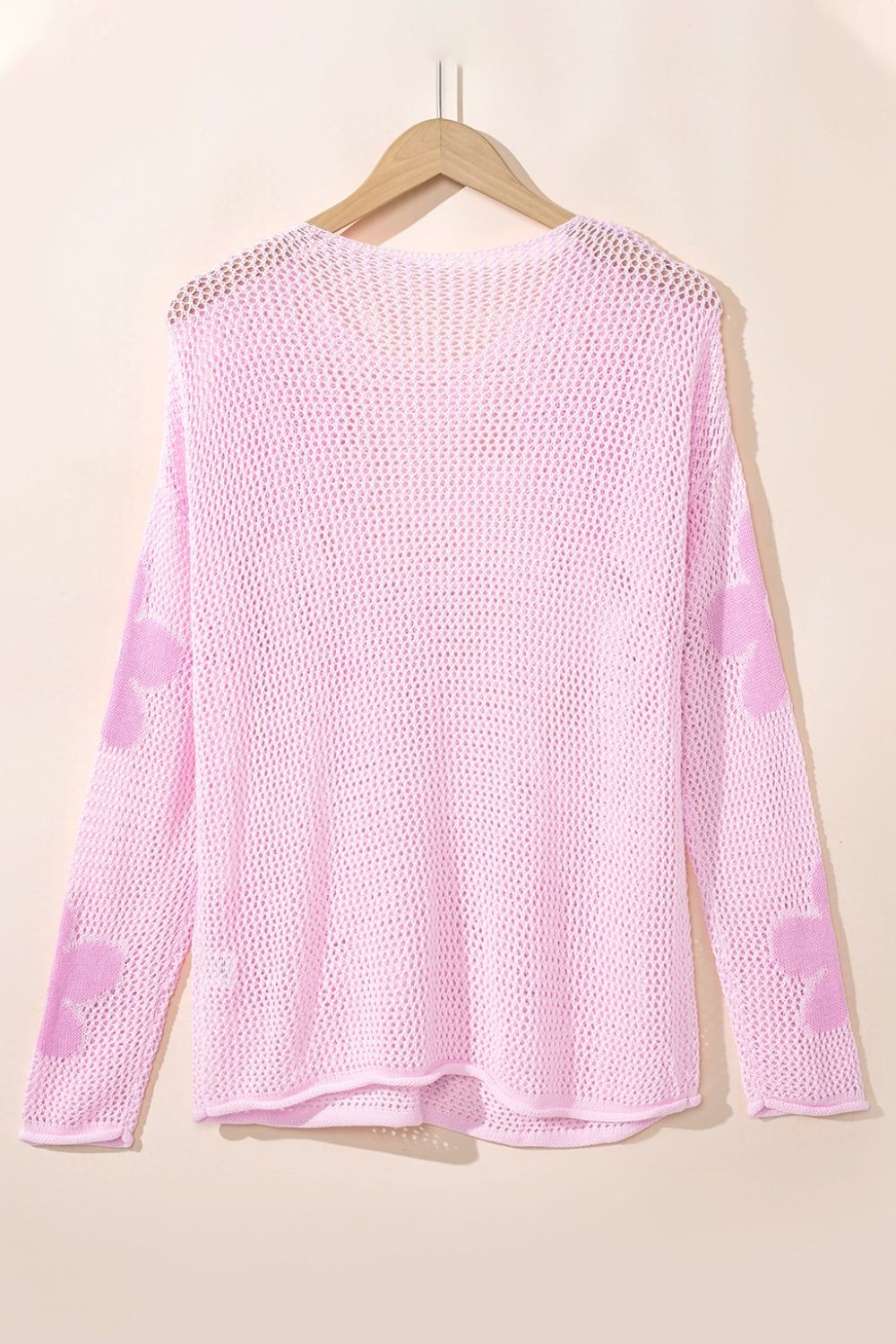 Blush pink openwork sweater with floral intarsia pattern on sleeves, acrylic knit.