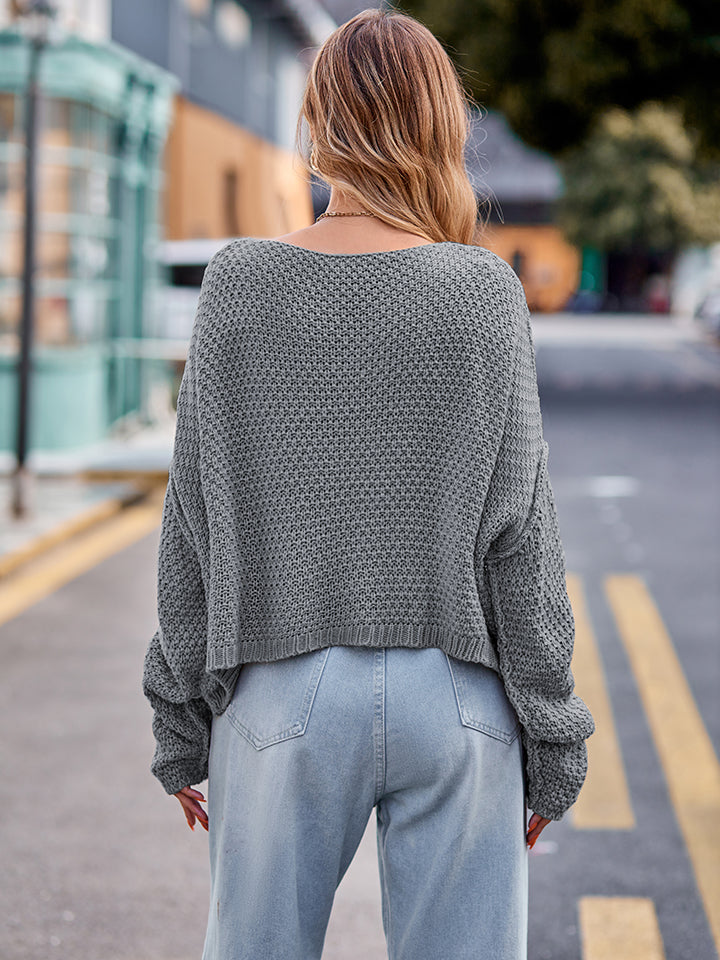 Charcoal knit sweater with textured pattern and wide neckline.
