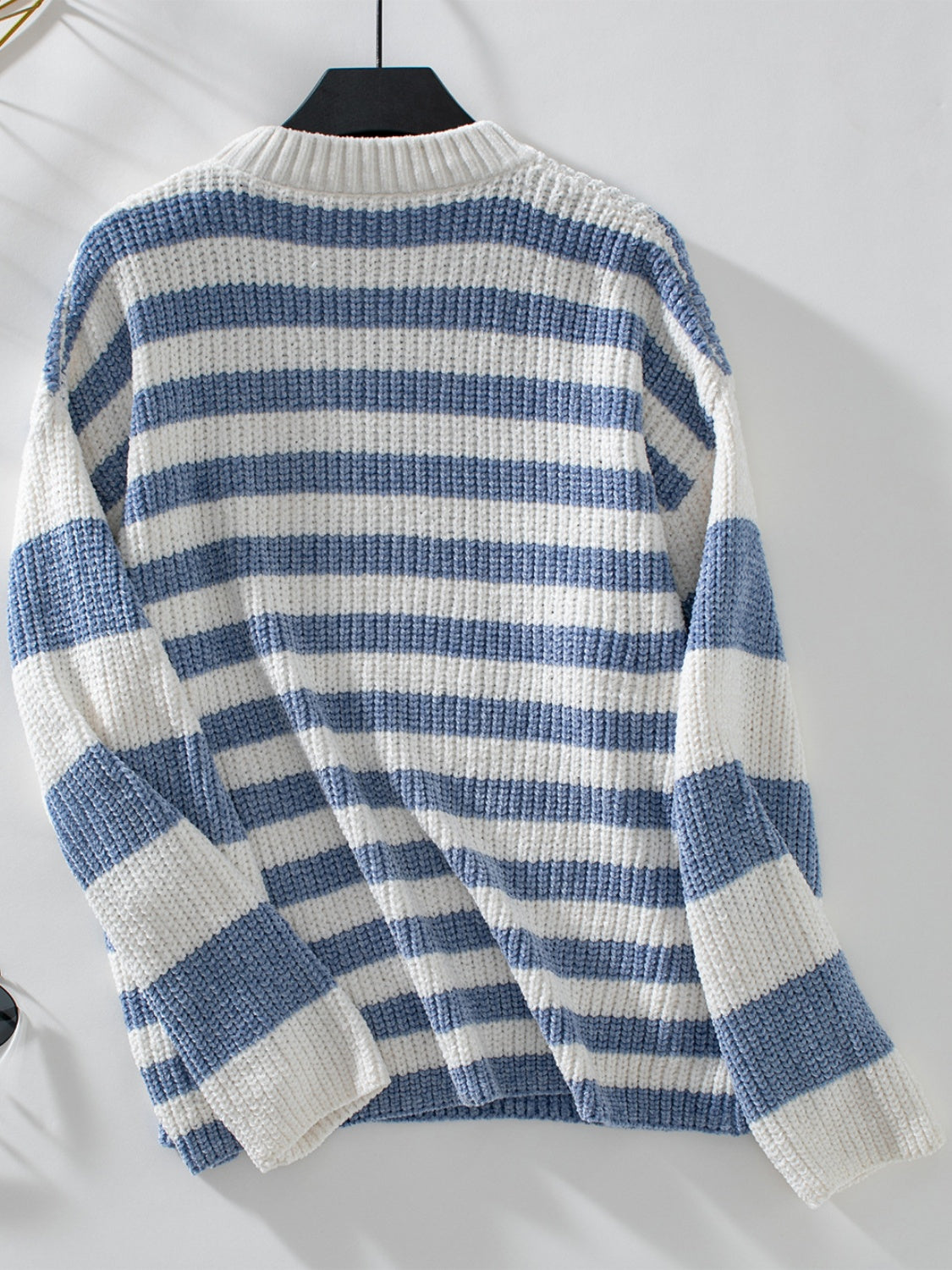 Light blue and white striped crewneck sweater with ribbed knit texture.