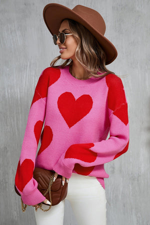Pink acrylic knit sweater with red heart pattern, crew neck, long sleeves.