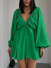 Green ruched V-neck dress with balloon sleeves and textured fabric.