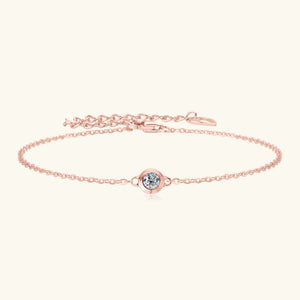 Rose gold chain bracelet with a single round moissanite stone in a bezel setting.