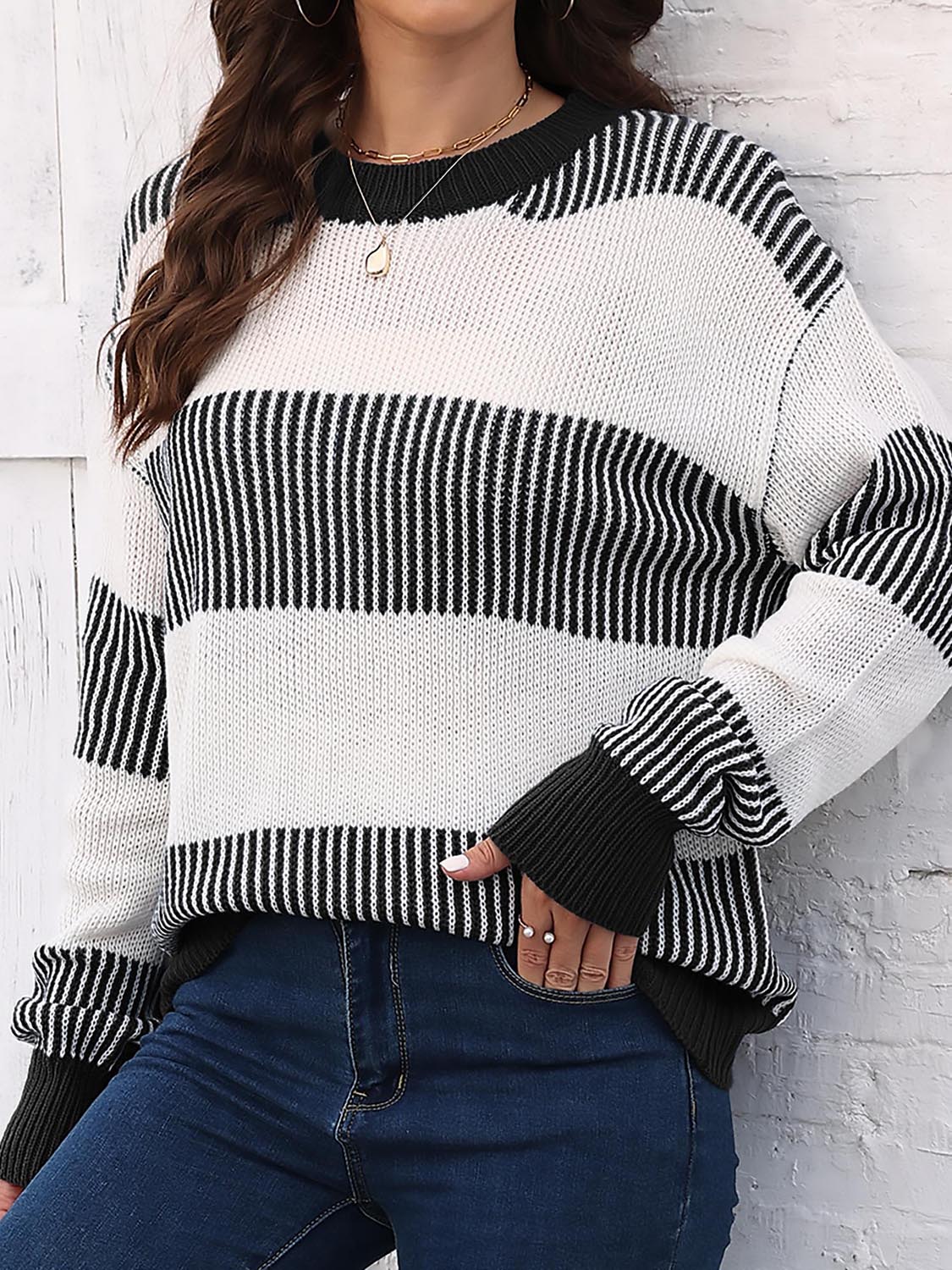 Striped knit crewneck sweater with ribbed trim in black and white acrylic.