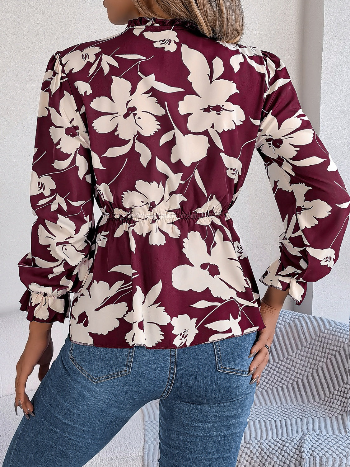 Burgundy floral peplum blouse with ruffled neck and cinched waist