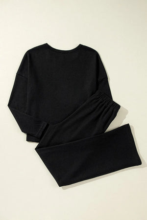 Black ribbed loungewear set with crewneck top and wide-leg pants.