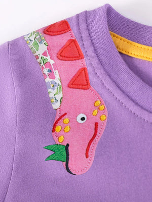 Purple cotton toddler dress with pink dinosaur applique and floral trim detail.