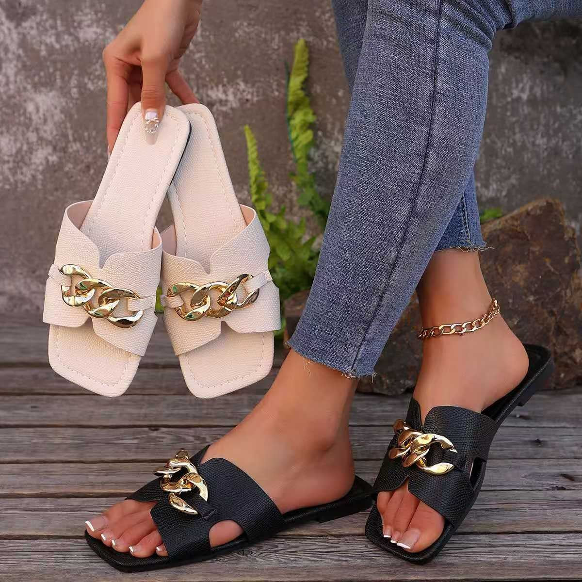 White and black chain-embellished slide sandals with modern elegance