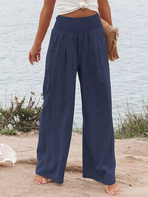 Dark blue smocked maternity pants with wide legs and a casual, chic style.