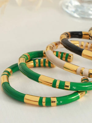 Striped enamel and gold bangle bracelet in dark green with gold accents.