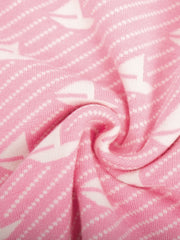 Blush pink knit sweater with white sailboat jacquard pattern and textured stripes.