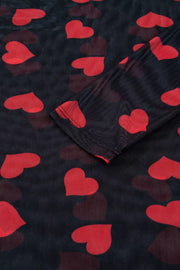 Sheer mesh blouse with red heart print and long sleeves.