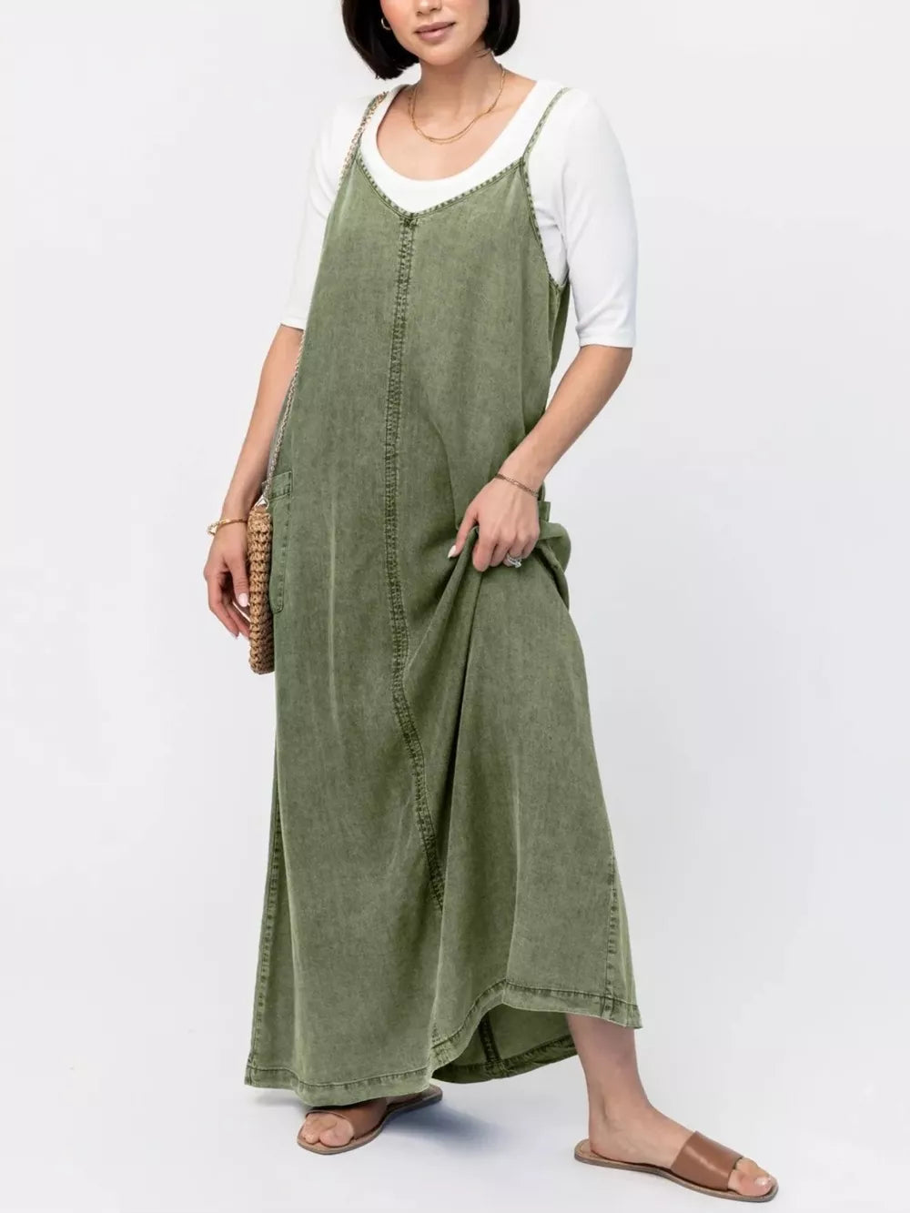 Moss denim maxi dress with V-neck and adjustable straps, styled with a white tee.