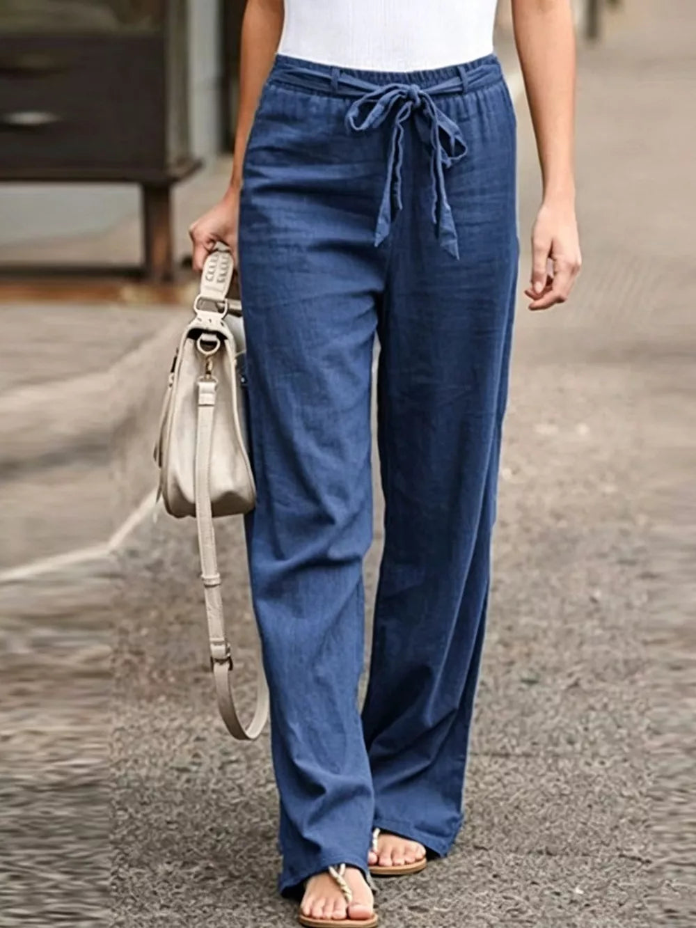 Blue maternity pants with relaxed wide legs and a tie detail at the waist.