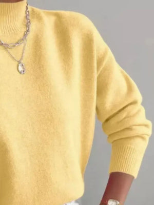 Light yellow mock neck knit sweater with dropped shoulders and ribbed cuffs.