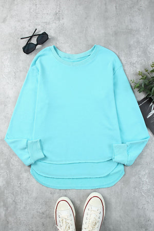 Aqua sweatshirt with asymmetric hemline and raw edge detail.