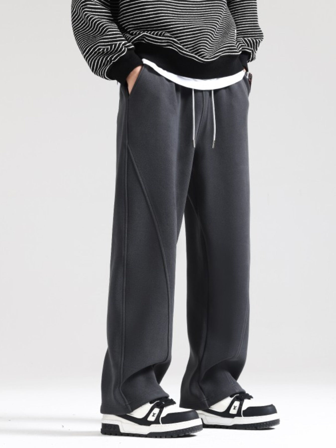 Men's grey wide-leg sweatpants with drawstring and seam detail.