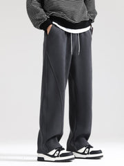 Men's grey wide-leg sweatpants with drawstring and seam detail.