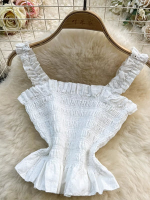 White eyelet ruffled crop top with smocked bodice and ruffled straps.