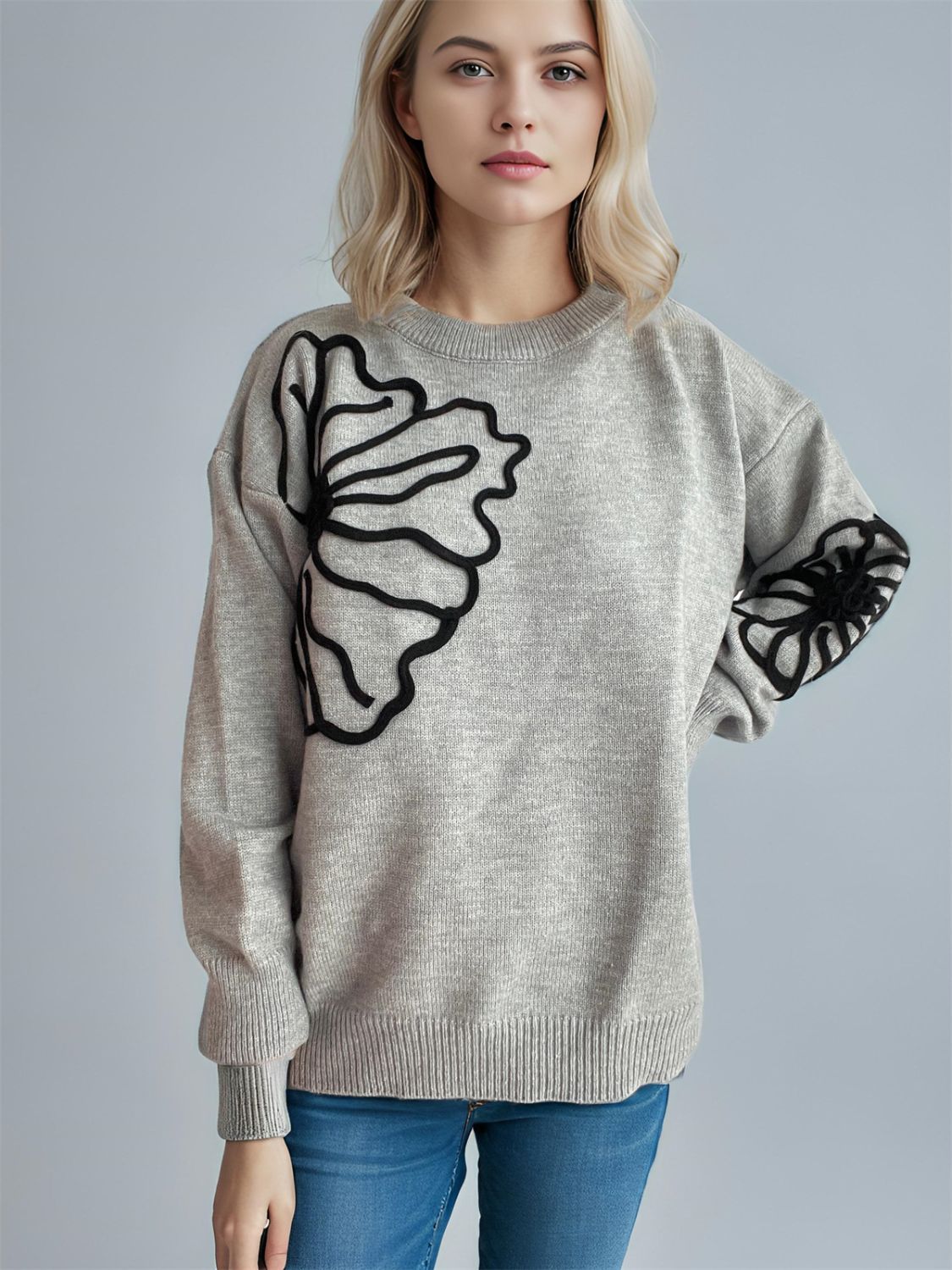 Gray knit sweater with black floral embroidery on the chest and sleeves.