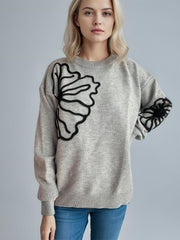 Gray knit sweater with black floral embroidery on the chest and sleeves.