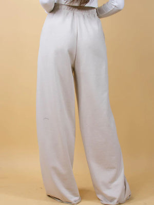 Wide-leg lounge pants in beige with an elastic waistband and a relaxed fit.