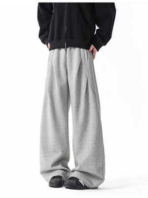 Men's gray wide-leg drawstring pants with a relaxed fit and subtle pleating.