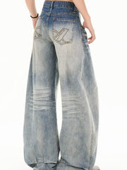 Men's light wash wide leg jeans with distressed details and embroidered back pockets.