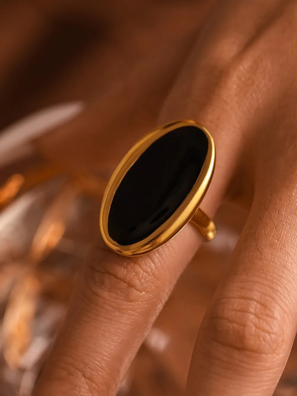 Gold cocktail ring with oval black onyx stone.