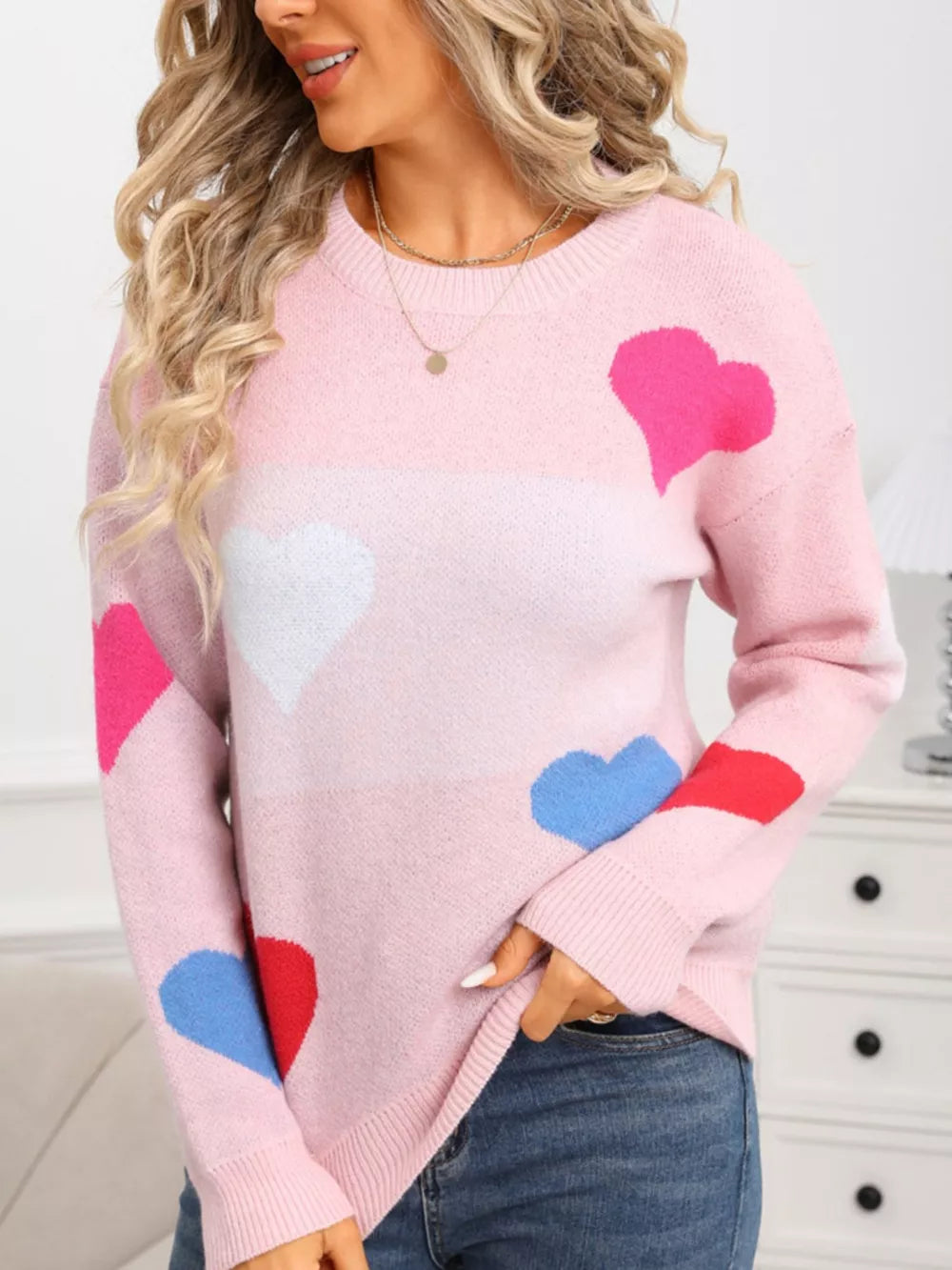 Pink acrylic knit sweater with round neck and multicolor heart pattern