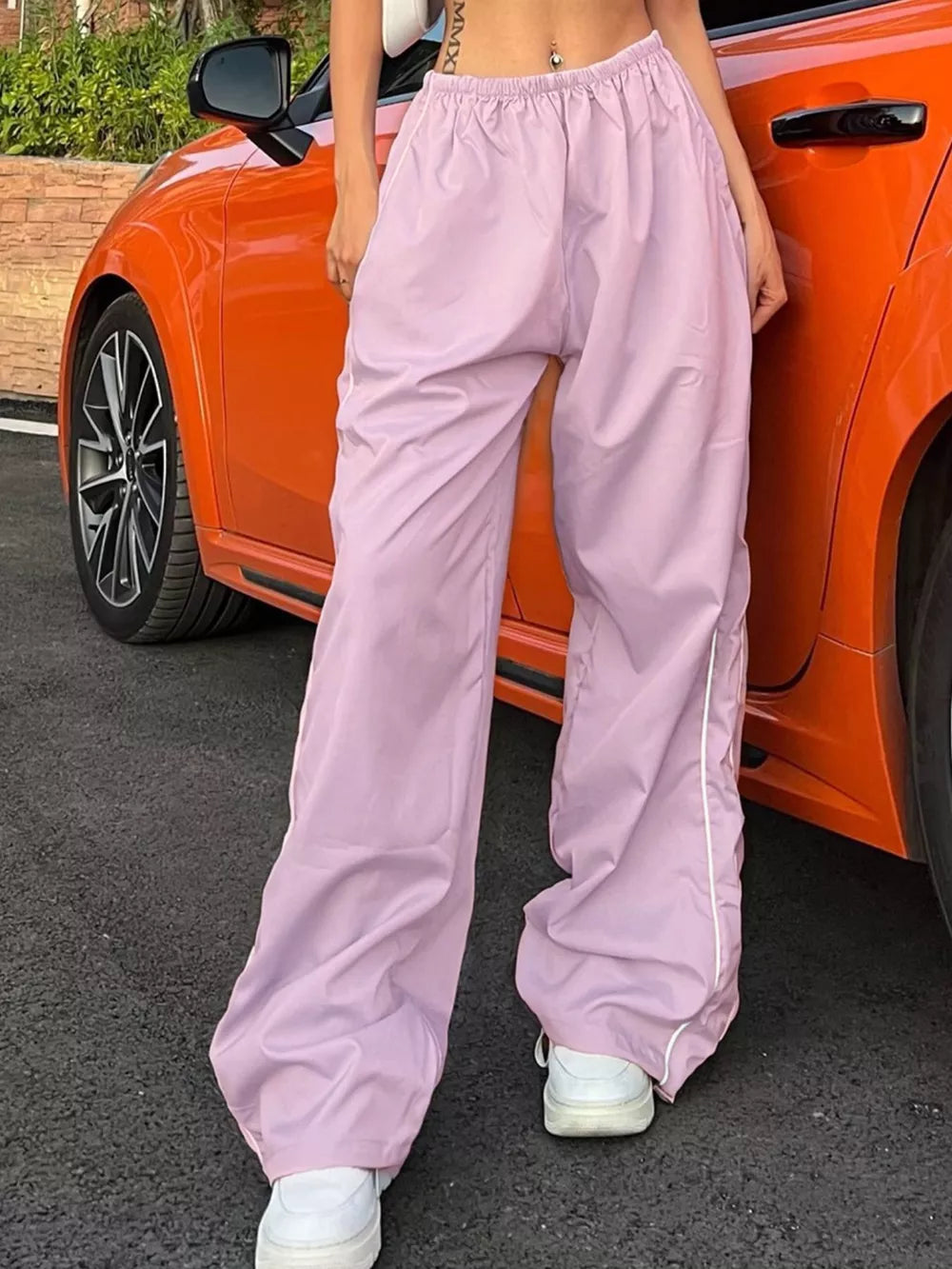 Pink wide-leg maternity trousers with gathered waistband and white side stripe detail.