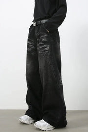 Faded black palazzo jeans in distressed denim with a wide leg and a casual fit.