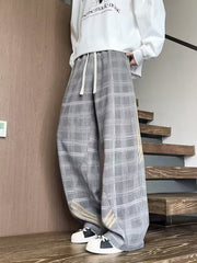 Men's gray plaid wide leg sweatpants with drawstring waist and subtle stripe detail.