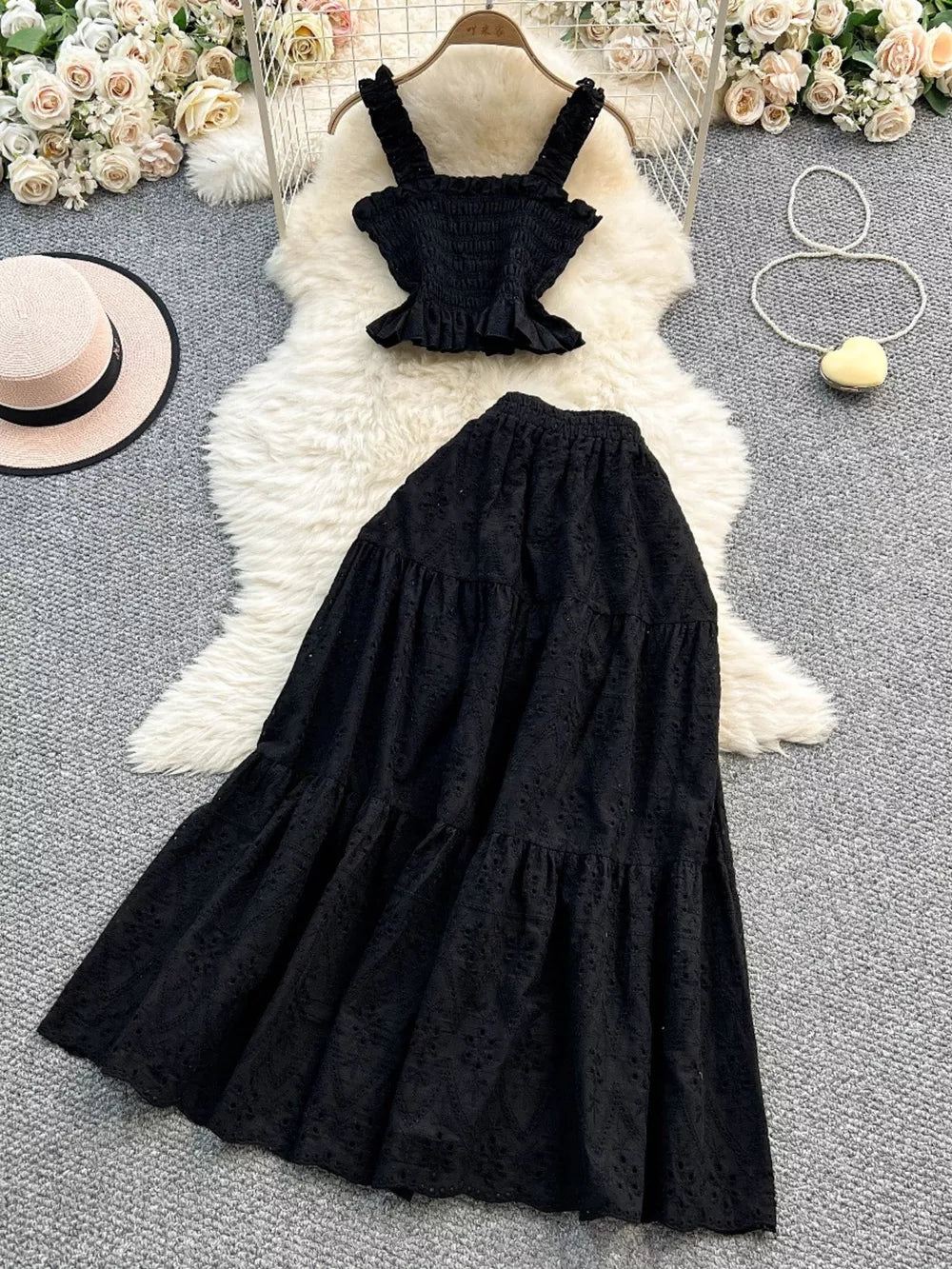 Black eyelet maxi skirt and ruffled crop top set with elastic waistband.
