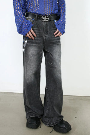 Painterly flare denim jeans in dark wash with white paint splatters and a wide leg cut.