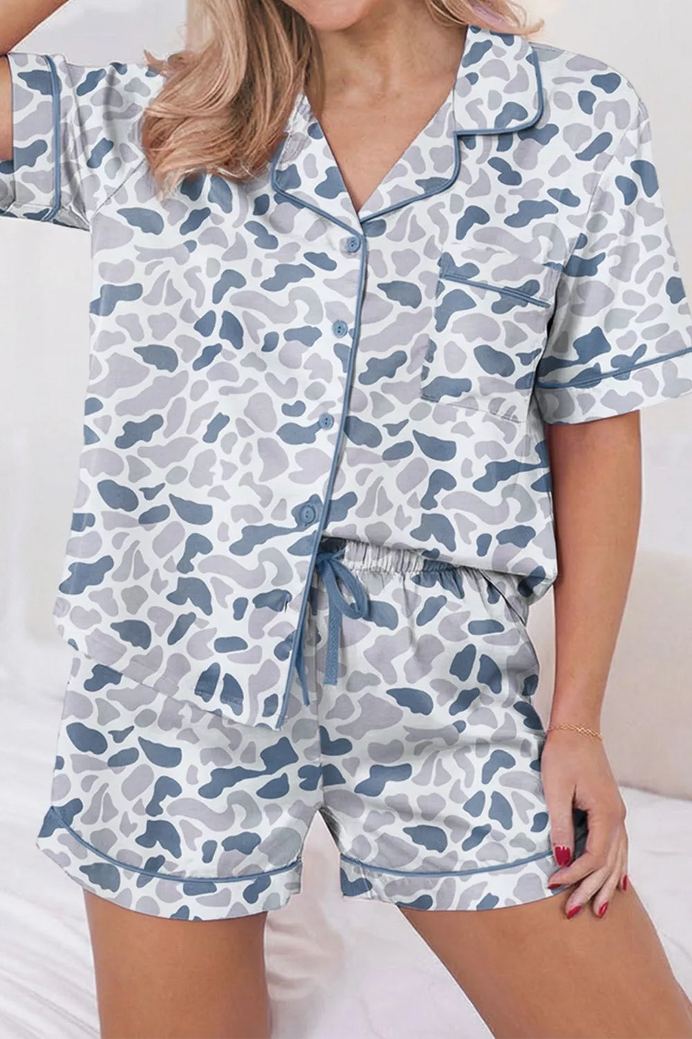 Blue camouflage print button-down pajama set with shorts and contrast piping.