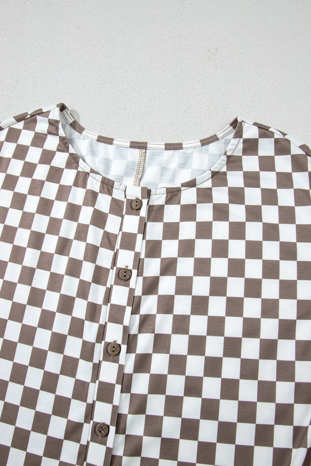 Checkered mocha palazzo jumpsuit with button front and cap sleeves.