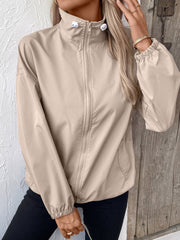 Nylon bomber jacket in beige with a drawstring hem and zippered front.