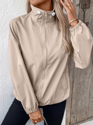 Nylon bomber jacket in beige with a drawstring hem and zippered front.