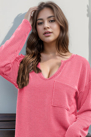 Coral ribbed plunge neck top with pocket and striped pattern.