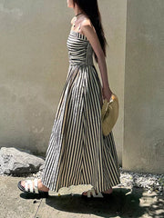 Black and white striped maxi dress with spaghetti straps and a thigh-high slit.