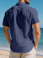 Navy blue short sleeve henley shirt with band collar, cotton fabric, and textured detail.