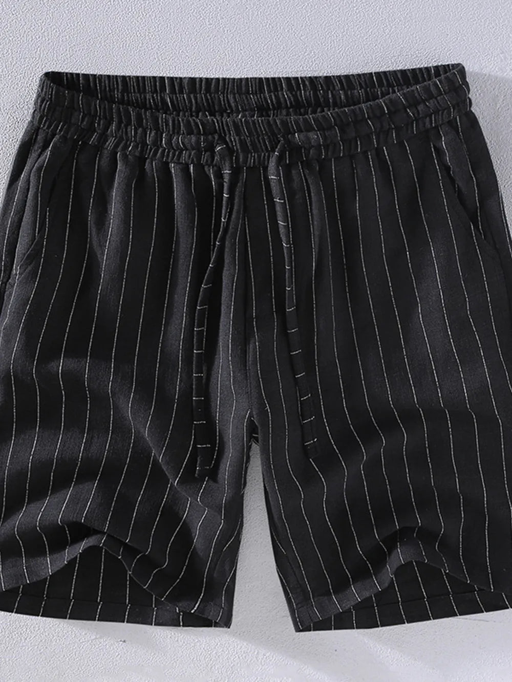 Black pinstripe chino shorts with drawstring waist and pockets.