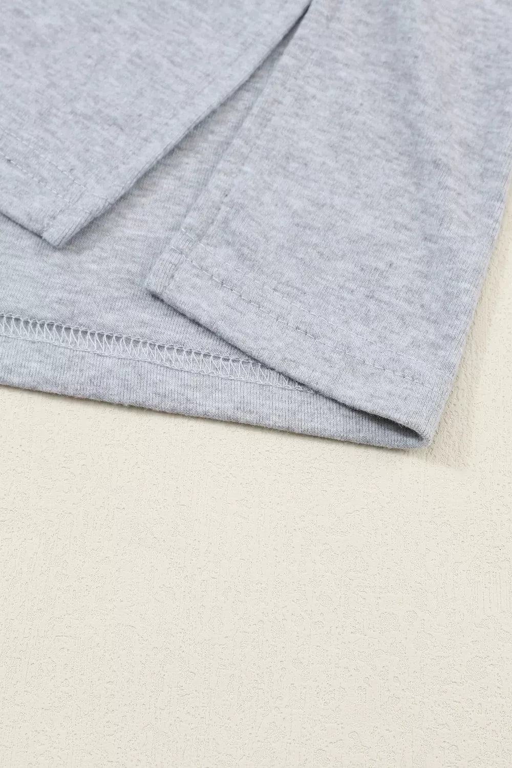 Gray maternity shirt with bishop sleeves and crew neck, showing hem detail.