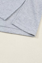 Gray maternity shirt with bishop sleeves and crew neck, showing hem detail.