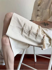 Beige chino shorts with drawstring and tassel detail, featuring decorative knot closures.