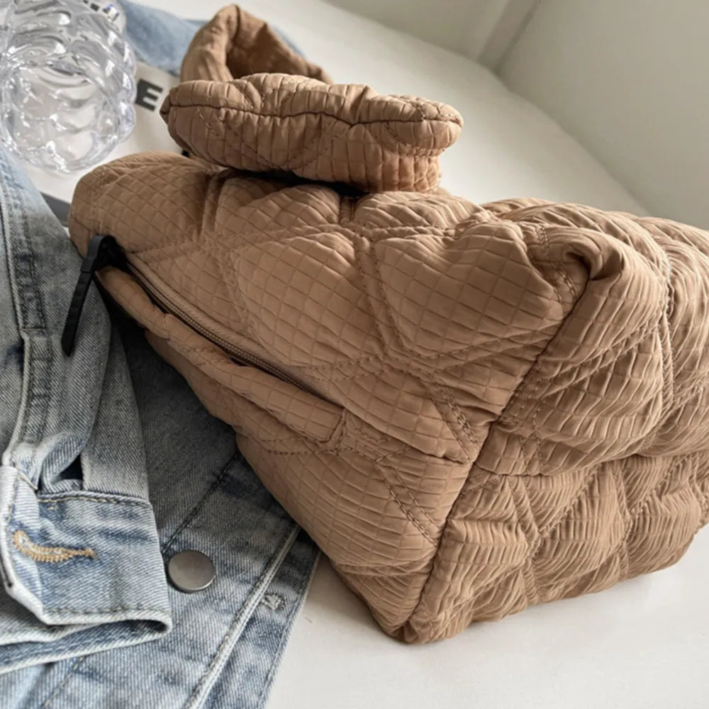 Quilted shopper tote bag in camel with a textured diamond pattern and a zip closure.