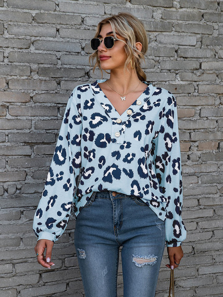 Sky blue leopard print henley blouse with blouson sleeves and button detail.