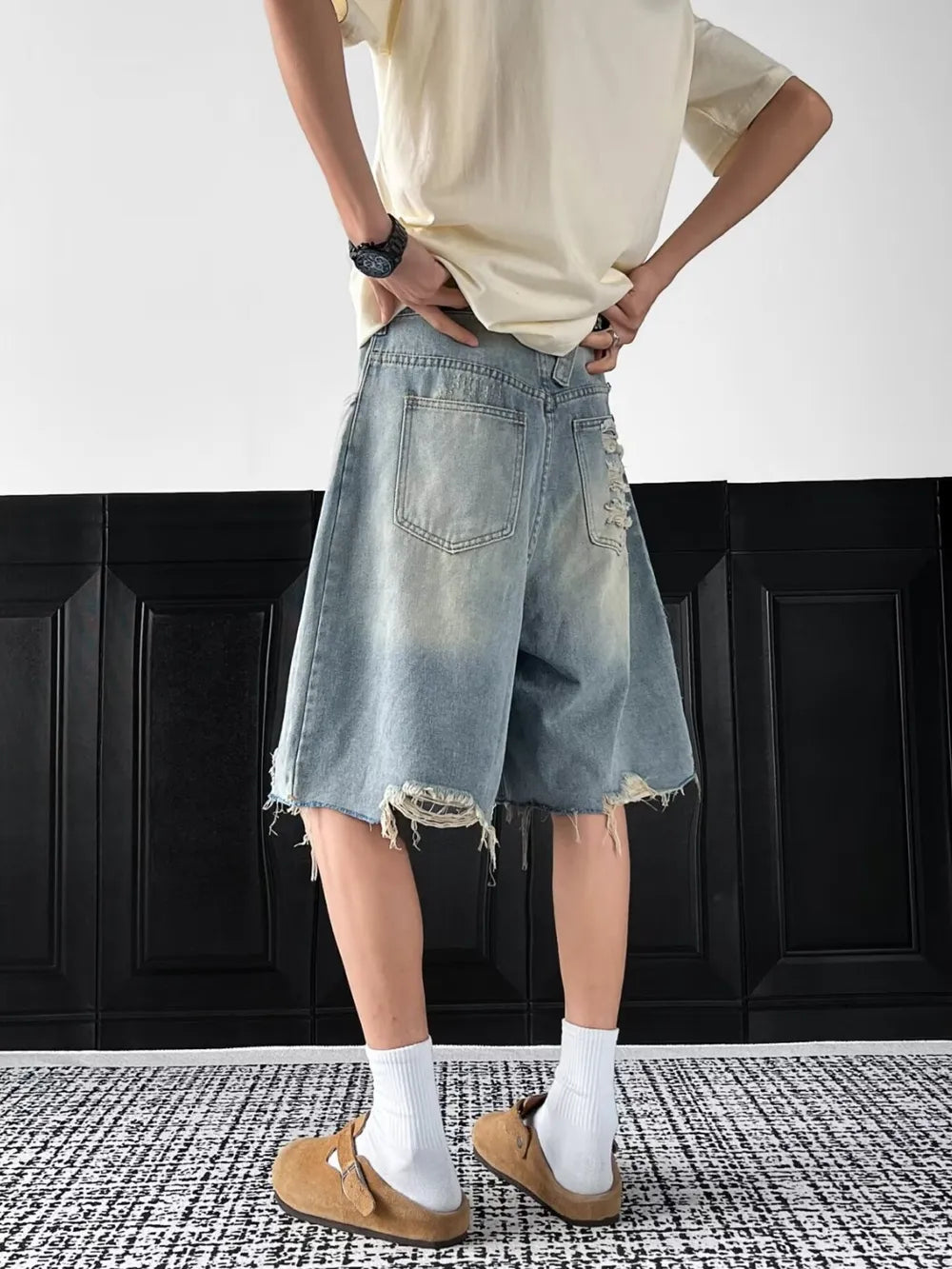 Light-wash distressed denim shorts with raw hem and ripped details.