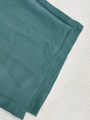 Turquoise cropped vest and wide-leg pants ensemble, textured fabric detail.