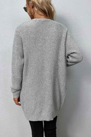 Light gray waffle knit longline cardigan with pockets, crew neck and long sleeves.